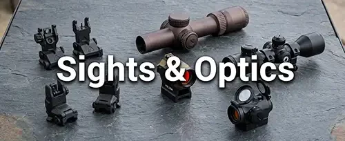 AR-15 sights and optics — flip-up backup iron sights, FDE rifle scope, and red dot sights on slate surface